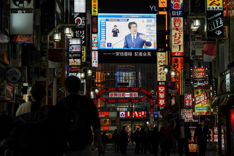 &copy; Reuters. FILE PHOTO: A large screen on a building shows Japan&apos;s Prime Minister Shinzo Abe declaring a state of emergency, at Tokyo&apos;s famous entertainment district Kabukicho, following the coronavirus disease (COVID-19) outbreak, in Tokyo
