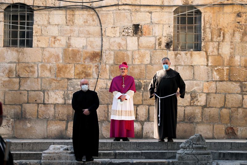 © Reuters. FILE PHOTO: Archbishop Pierbattista Pizzaballa, apostolic administrator of the Latin Patriarchate of Jerusalem stands at the entrance to the Church of the Holy Sepulchre amid coronavirus restrictions in Jerusalem's Old City