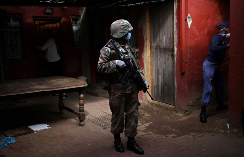 &copy; Reuters. FILE PHOTO: A soldier and a member of the South African police service search a house