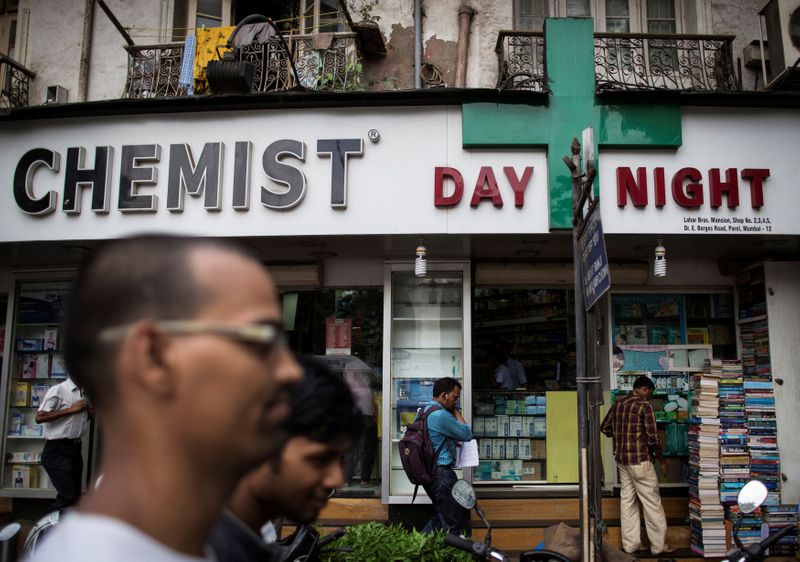 &copy; Reuters. FILE PHOTO: FILE PHOTO: People walk past a chemist shop at a market in Mumbai