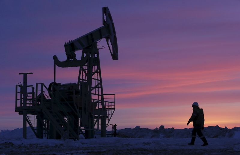 &copy; Reuters. File photo of a worker walking past a pump jack on an oil field owned by Bashneft company near Nikolo-Berezovka