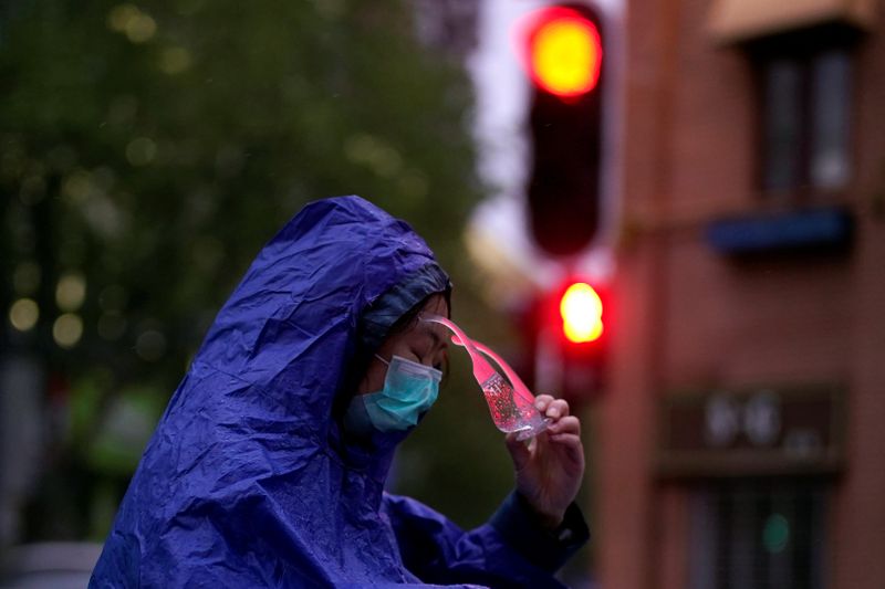 © Reuters. A woman wearing a face mask is seen on a street after the lockdown was lifted in Wuhan