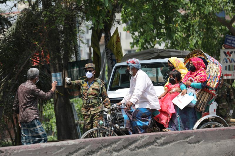 &copy; Reuters. An army personnel stops people riding on a rickshaw at a check post during government imposed countrywide shutdown amid concerns over the coronavirus disease (COVID-19) outbreak in Narayanganj