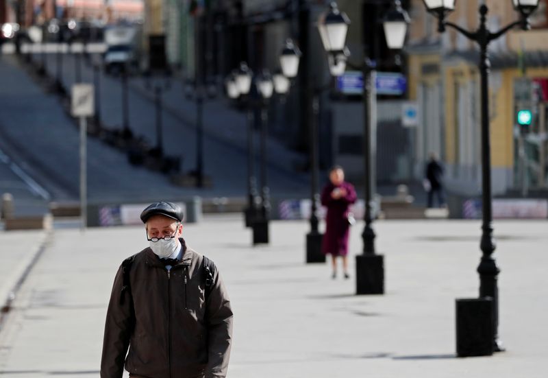 &copy; Reuters. A man wearing a protective face mask walks along the street in Moscow