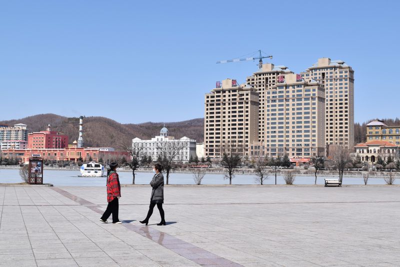 &copy; Reuters. People wearing face masks are seen at a park in Suifenhe, a city of Heilongjiang province on the border with Russia, as the spread of the novel coronavirus disease (COVID-19) continues in the country