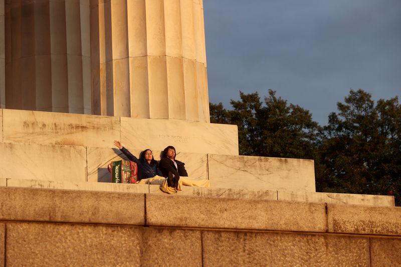 © Reuters. A young couple pray at Easter sunrise at the Lincoln Memorial during the coronavirus disease (COVID-19) outbreak in Washington