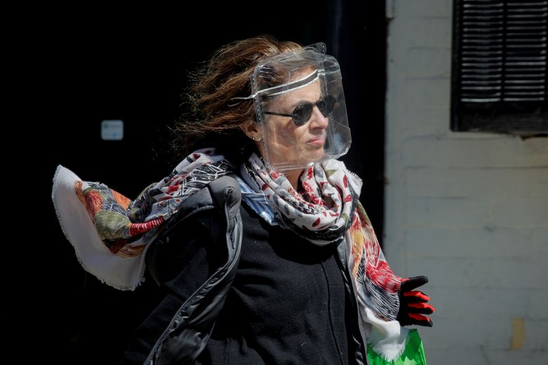 &copy; Reuters. Una mujer lleva un recipiente de plástico para alimentos para protegerse durante el brote de la enfermedad coronavirus (COVID19) en el distrito de Brooklyn de Nueva York, EEUU