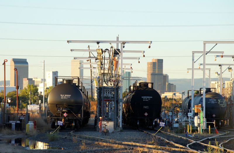 &copy; Reuters. FILE PHOTO: Oil tanker railcars are parked at a filling rack at sunrise with the Denver downtown skyline in the background