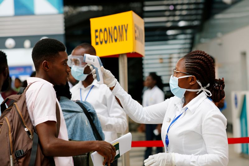 © Reuters. FOTO DE ARCHIVO: Un trabajador de salud verifica la temperatura de un viajero como parte del procedimiento de detección de coronavirus en el Aeropuerto Internacional de Kotoka en Accra,