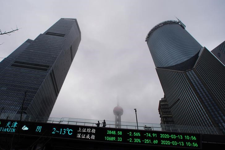 &copy; Reuters. Пешеходный переход с электронным табло с фондовыми индексами в Шанхае