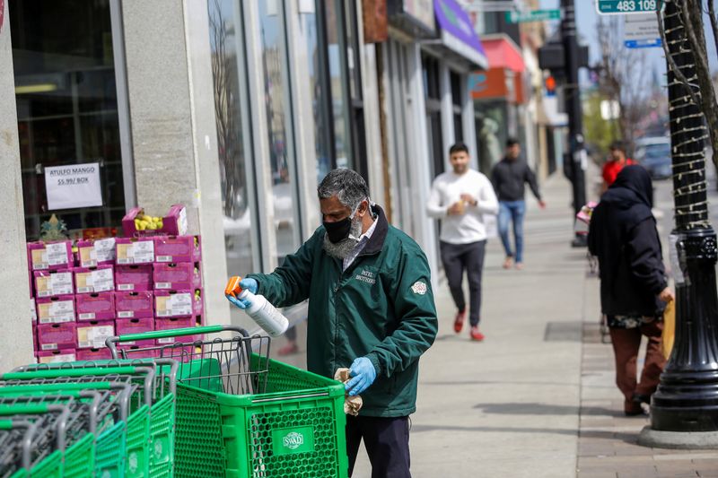 &copy; Reuters. A worker for Patel Brothers grocery store spays and wipes down a shopping cart during the global outbreak of coronavirus disease (COVID-19) in Chicago