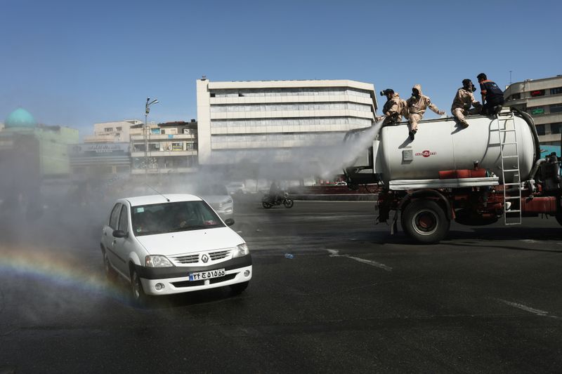&copy; Reuters. Voluntários desinfetam rua de Teerã em meio a pandemia de Covid-19