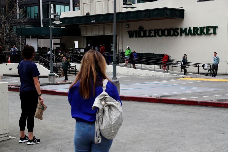 © Reuters. Unidade do mercado Whole Foods em San Francisco, Califórnia, com clientes praticando distanciamento social em fila durante pandemia de coronavírus