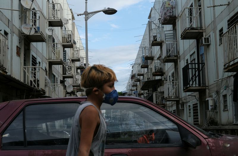 &copy; Reuters. Menino com máscara de proteção na favela de Manguinhos, no Rio de Janeiro