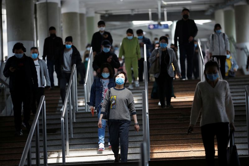&copy; Reuters. People wearing face masks walk inside a subway station during morning rush hour in Beijing, as the spread of the novel coronavirus disease (COVID-19) continues in the country