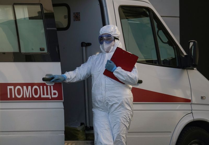&copy; Reuters. Медработник в защитном костюме у больницы, где проходят лечение пациенты с коронавирусом