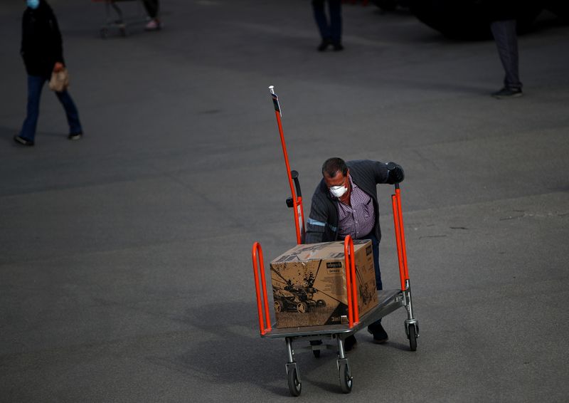 &copy; Reuters. Un hombre lleva un carrito de compras fuera de una ferretería durante la reapertura parcial de las tiendas en Viena, Austria, el 14 de abril de 2020