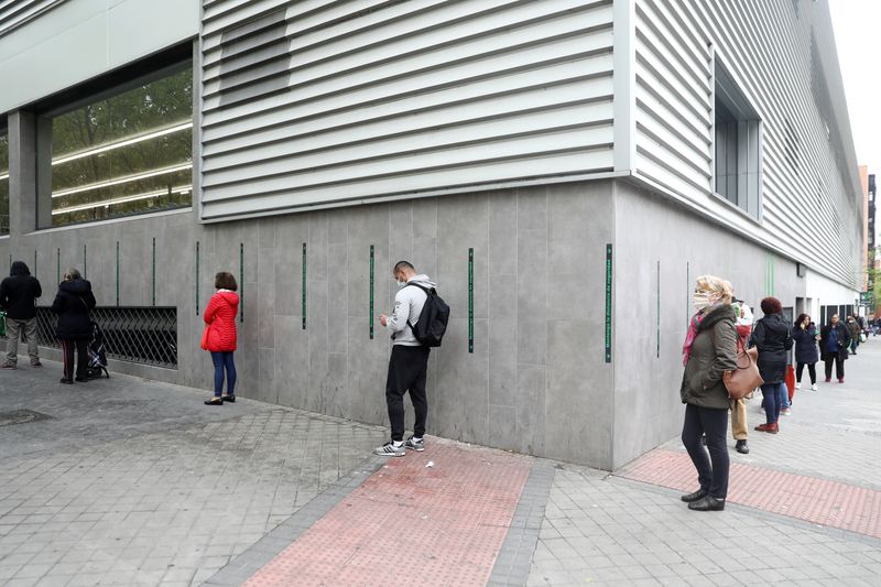 &copy; Reuters. Pessoas mantêm distanciamento social em fila para entrar em supermercado em Madri