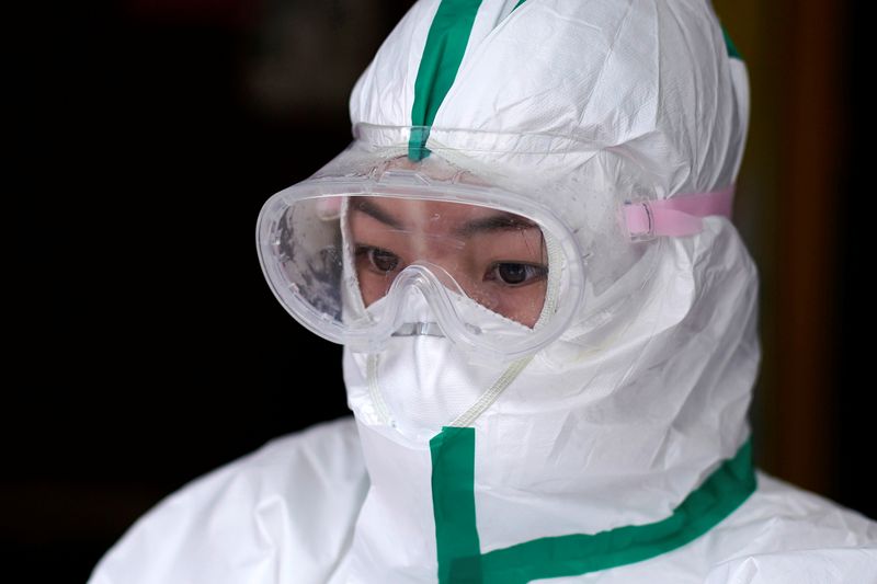 &copy; Reuters. Agente de saúde com roupa de proteção aguarda resultado de exames para Covid-19 em Wuhan, epicentro da doença na China