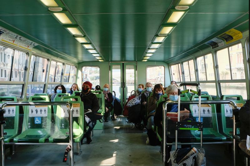 &copy; Reuters. Alcuni passeggeri a bordo di un vaporetto indossano mascherine e guanti protettivi durante la crisi coronavirus a Venezia, 4 aprile 2020