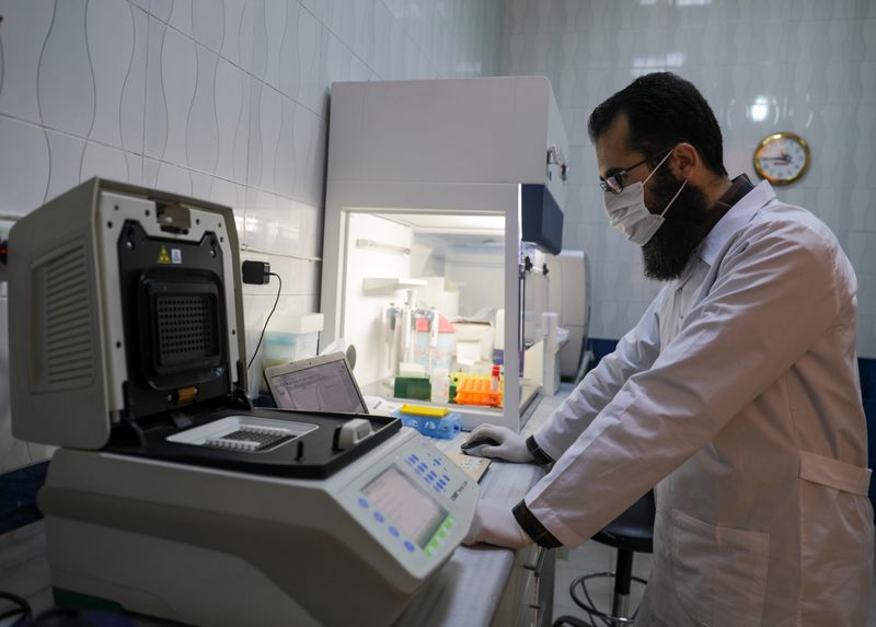 © Reuters. Mohamad Shahim Makki, a doctor, wears protective gear as he works at a laboratory that deals with coronavirus disease (COVID-19) testing in Idlib