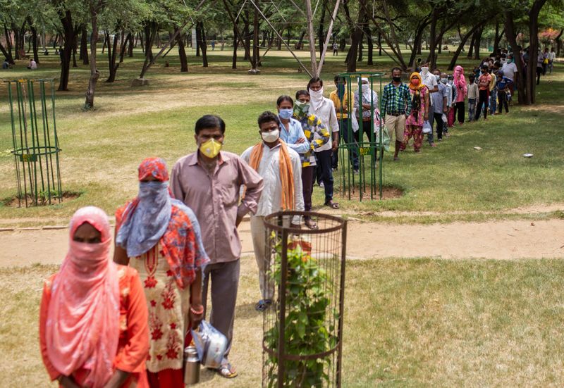 &copy; Reuters. Pessoas fazem fila para pegar comida distribuída pelo governo em Nova Délhi