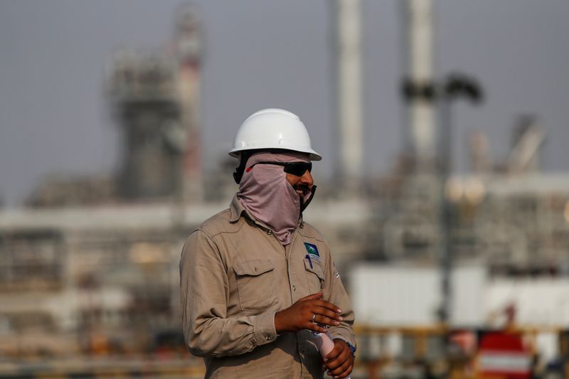 © Reuters. FILE PHOTO: An employee looks on at Saudi Aramco oil facility in Abqaiq