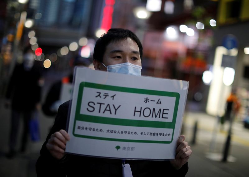 &copy; Reuters. A staff members of the Tokyo metropolitan government wearing a protective face mask march as he calls for people to stay home following the coronavirus disease outbreak in Tokyo