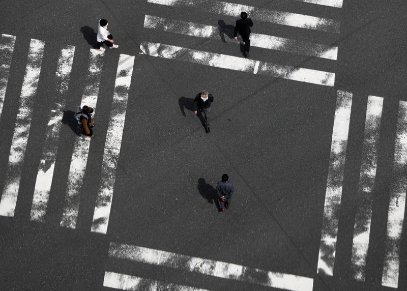 &copy; Reuters. Прохожие на пешеходном переходе в Токио