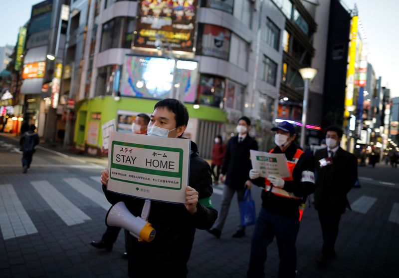 &copy; Reuters. Staff members of the Tokyo metropolitan government wearing protective face masks march as they call for people to stay home following the coronavirus disease outbreak in Tokyo