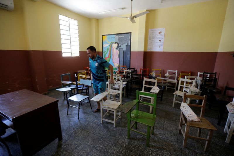 &copy; Reuters. Foto de archivo. Un hombre mueve las sillas en el aula de una escuela pública después de que el gobierno cerró las escuelas y suspendió los eventos a gran escala por el brote de coronovirus, en San Antonio, Paraguay.
