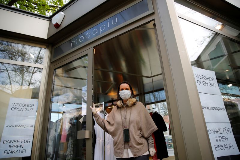 &copy; Reuters. Una donna posa davanti a un negozio di abbigliamento di sua proprietà a Vienna, 14 aprile 2020