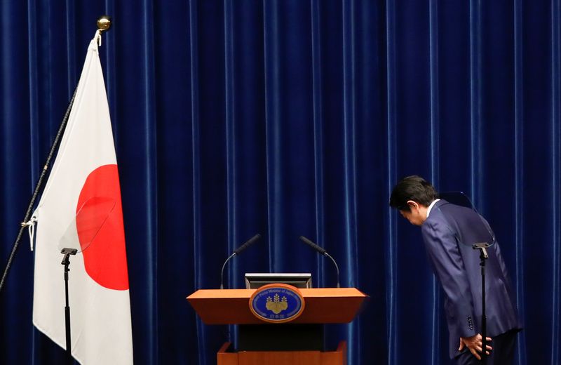 © Reuters. Premiê Shinzo Abe reverencia bandeira do Japão antes de coletiva de impensa sobre novo coronavírus