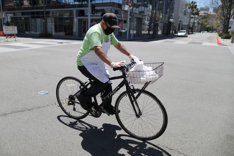 © Reuters. A food delivery driver cycles on an empty road as the global outbreak of the coronavirus disease (COVID-19) continues, in Beverly Hills