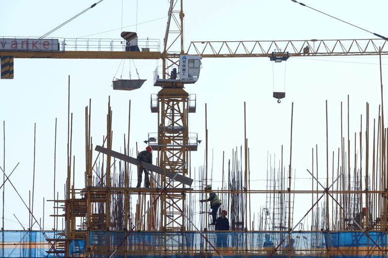 &copy; Reuters. FILE PHOTO:  Vanke sign is seen above workers working at the construction site of a residential building in Dalian