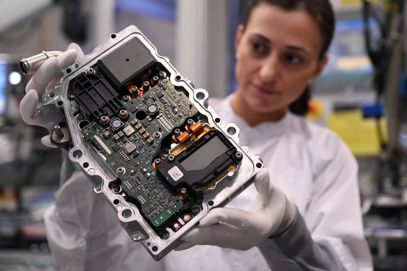 &copy; Reuters. Una dipendente del produttore tedesco di parti per automobili Continental ispeziona un componente di elettronica in una fabbrica, a Norimberga