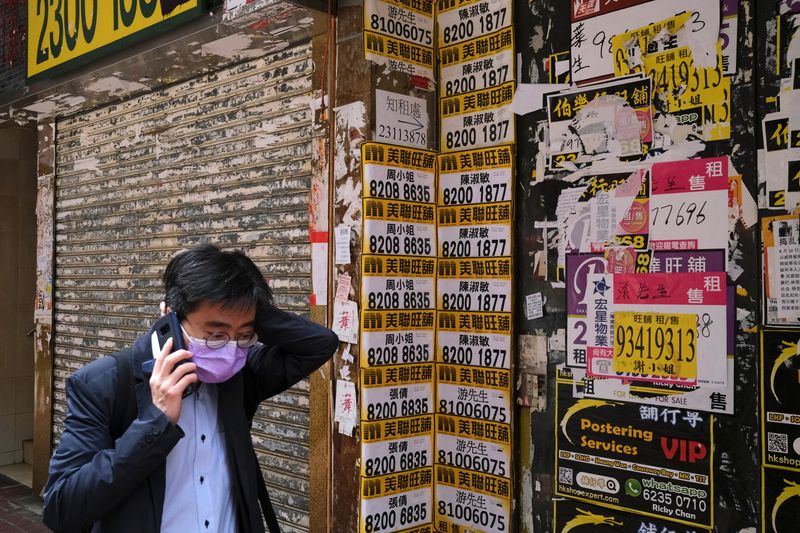 &copy; Reuters. A man wearing protective mask walks past a closed shop covered with advertisements for rental space at Mongkok, following the outbreak of the new coronavirus, in Hong Kong