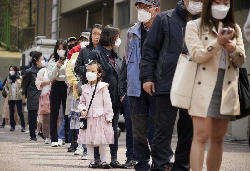 &copy; Reuters. Pessoas com máscara para evitar disseminação do coronavírus em fila para votar em eleição na Coreia do Sul