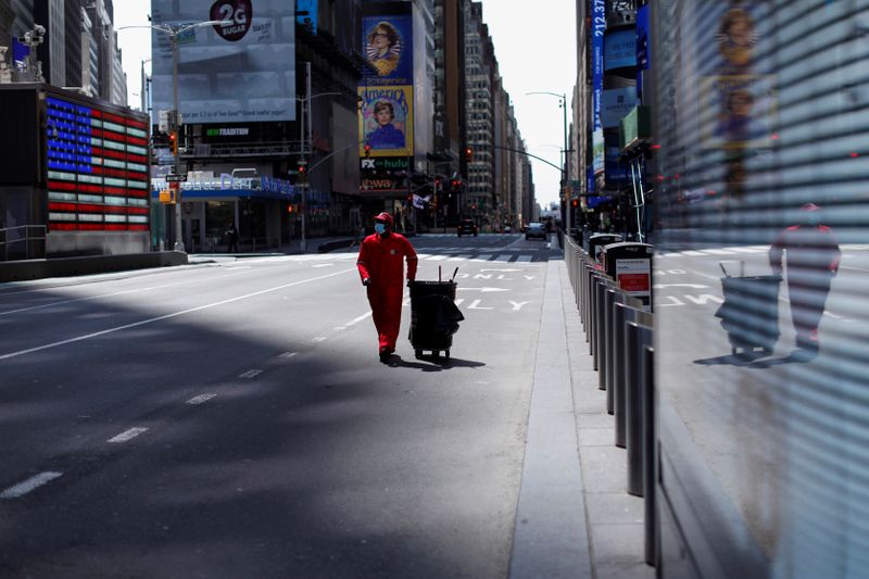 © Reuters. El barrendero camina por Times Square casi vacío durante el brote de la enfermedad por coronavirus (COVID-19) en Nueva York