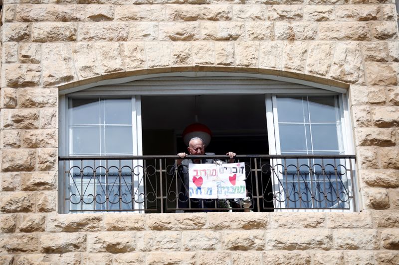 © Reuters. Elias Feinzilberg, a 102-year-old Holocaust survivor, stands at the window of his home in Jerusalem as Israel marks Holocaust Remembrance Day under coronavirus disease (COVID-19) restrictions