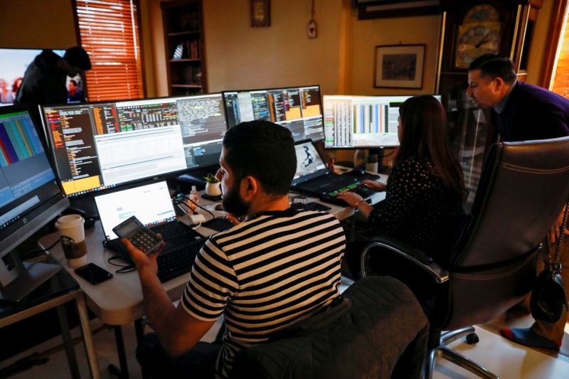 &copy; Reuters. Трейдеры Нью-Йоркской фондовой биржи из TradeMas Inc. работают в офисе на время закрытия здания биржи из-за пандемии COVID-19