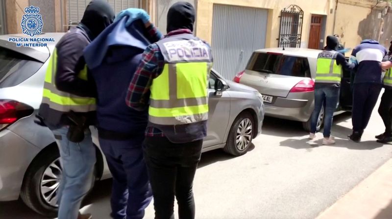 &copy; Reuters. Hombres con la cabeza cubierta son llevados fuera de un edificio en Almería, España, el 21 de abril de 2020, en esta foto tomada de un video.