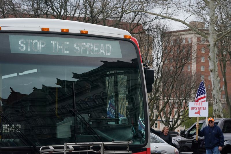 &copy; Reuters. Ônibus passa por manifestantes que protestam contra medidas de isolamento do coronavírus em Nova York