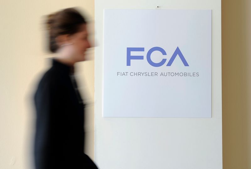 &copy; Reuters. A woman walks past a logo of Fiat Chrysler Automobiles (FCA) in Turin