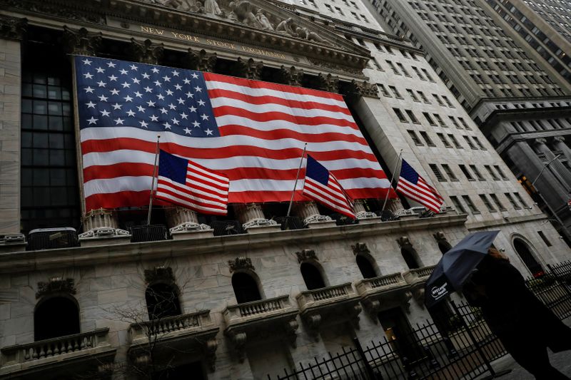 &copy; Reuters. A woman walks in the rain outside the New York Stock Exchange (NYSE) in the financial district of lower Manhattan during outbreak of coronavirus disease (COVID-19) in New York