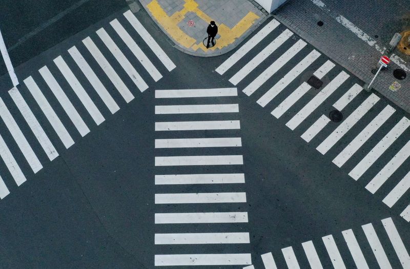&copy; Reuters. A man waits to cross a street in front of Shinjuku station in Tokyo