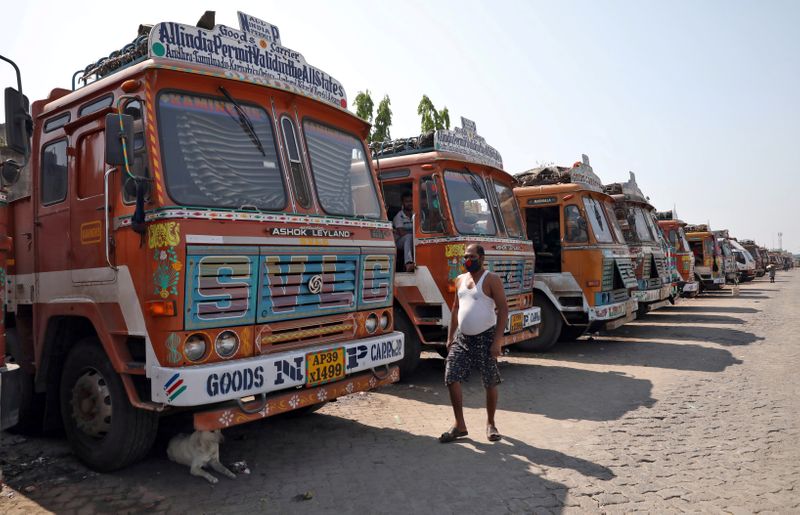 &copy; Reuters. FILE PHOTO: A man walks past parked supply trucks at a yard during a 21-day nationwide lockdown to limit the spreading of coronavirus disease (COVID-19), on the outskirts of Kolkata