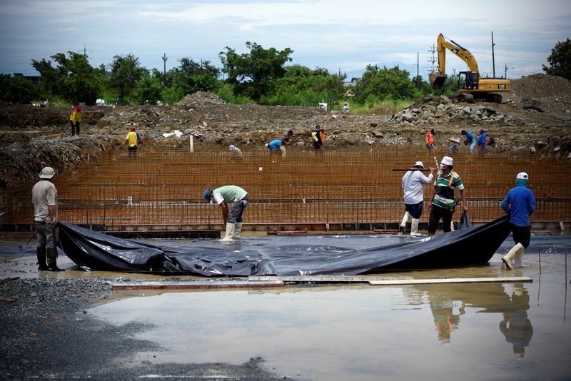 &copy; Reuters. FOTO DE ARCHIVO: Un grupo de obreros trabajando en la ampliación del cementerio Angel Maria Canals en Guayaquil, en medio de la pandemia de coronavirus