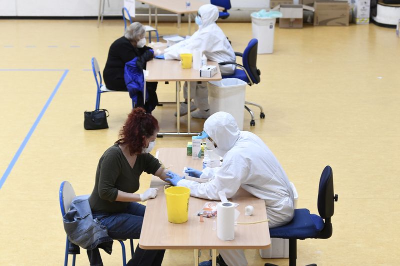 &copy; Reuters. Operatori sanitari effettuano dei test per COVID-19 a Cisliano, vicino Milano