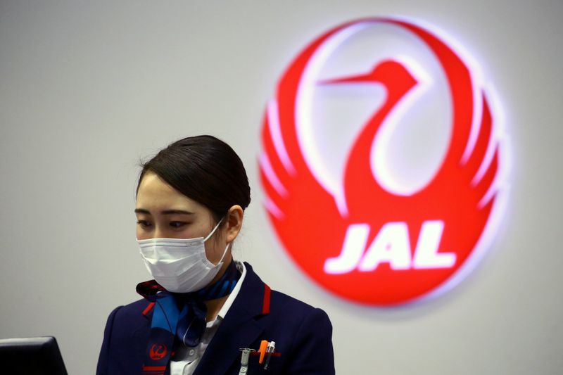 © Reuters. FILE PHOTO: An employee of Japan Airlines (JAL) is pictured at Kansai International Airport in Osaka